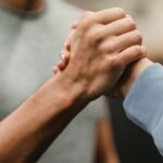 Techniques - Crop sportive couple clasping hands in gym