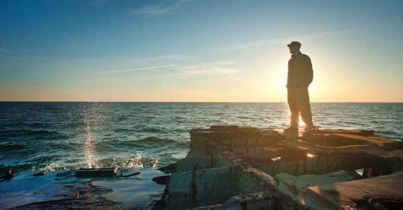 Dreams - Silhouette Photo of Man Standing Near the Edge of Concrete Pavement