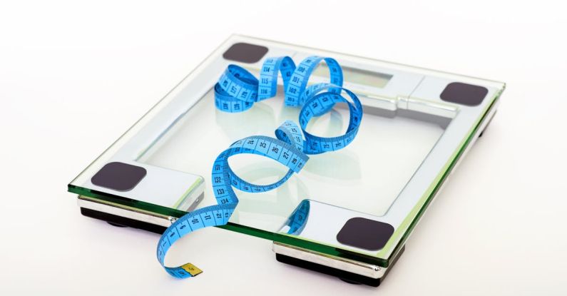 Diet - Blue Tape Measuring on Clear Glass Square Weighing Scale