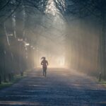 Exercise - Person Running Near Street Between Tall Trees